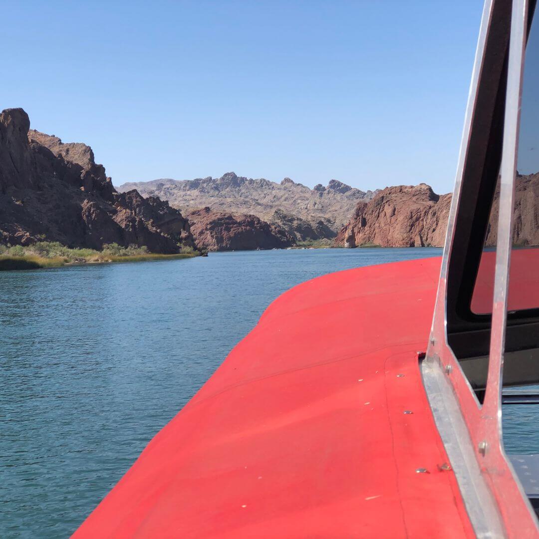 a small boat in a body of water with a mountain in the background