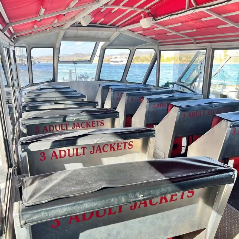 Interior of a small boat with seating labeled '3 ADULT JACKETS', red and gray color scheme.